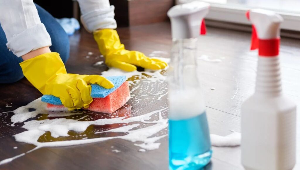 a person cleaning the floor with chemicals showing cleaning checklist for South African Homes